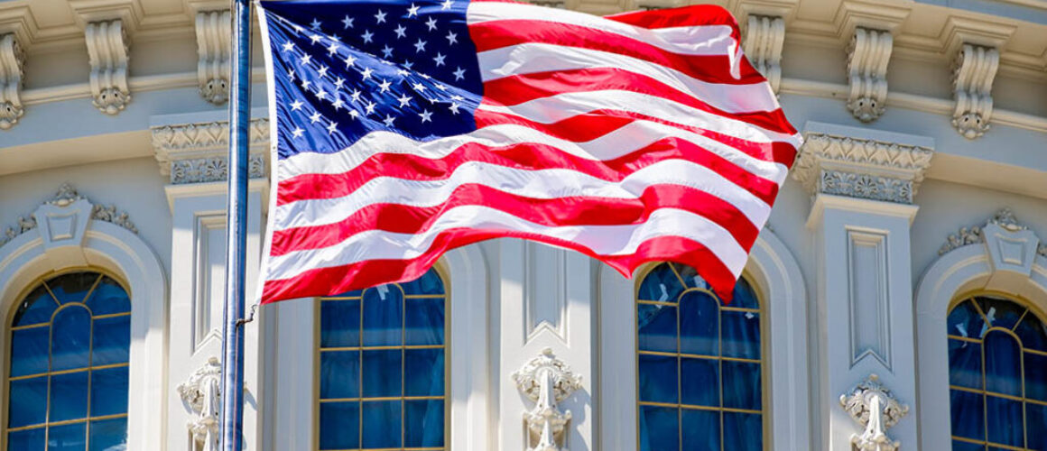 The American Flag waves in fron of the Capitol building in Washi