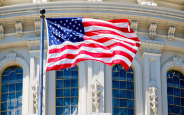 The American Flag waves in fron of the Capitol building in Washi